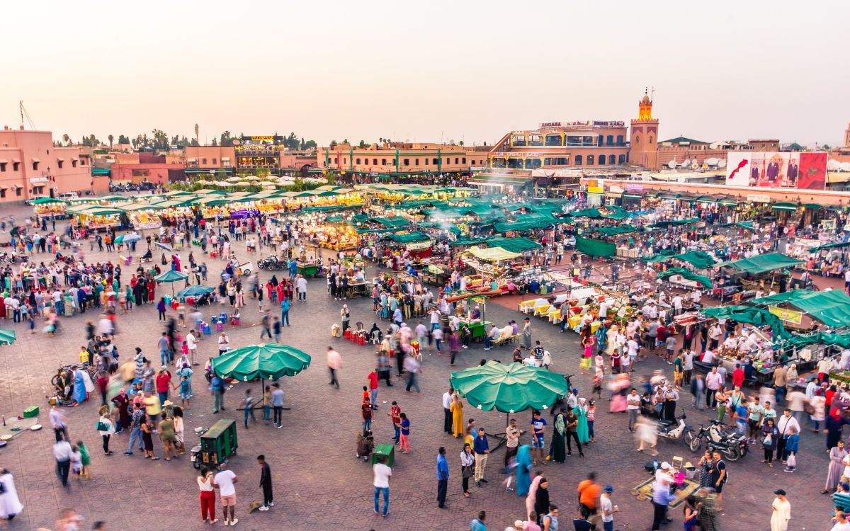 a large crowd of people in a square with tents and buildings