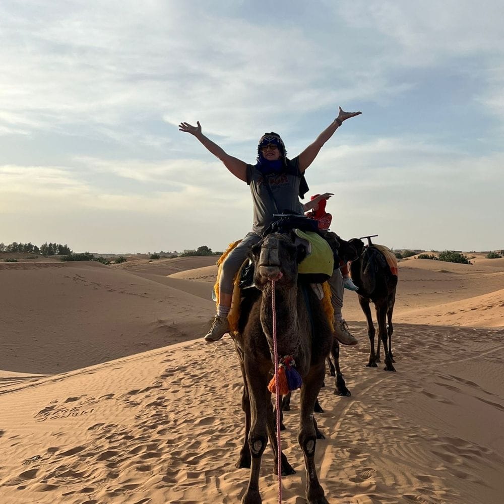 a person riding a camel in the desert